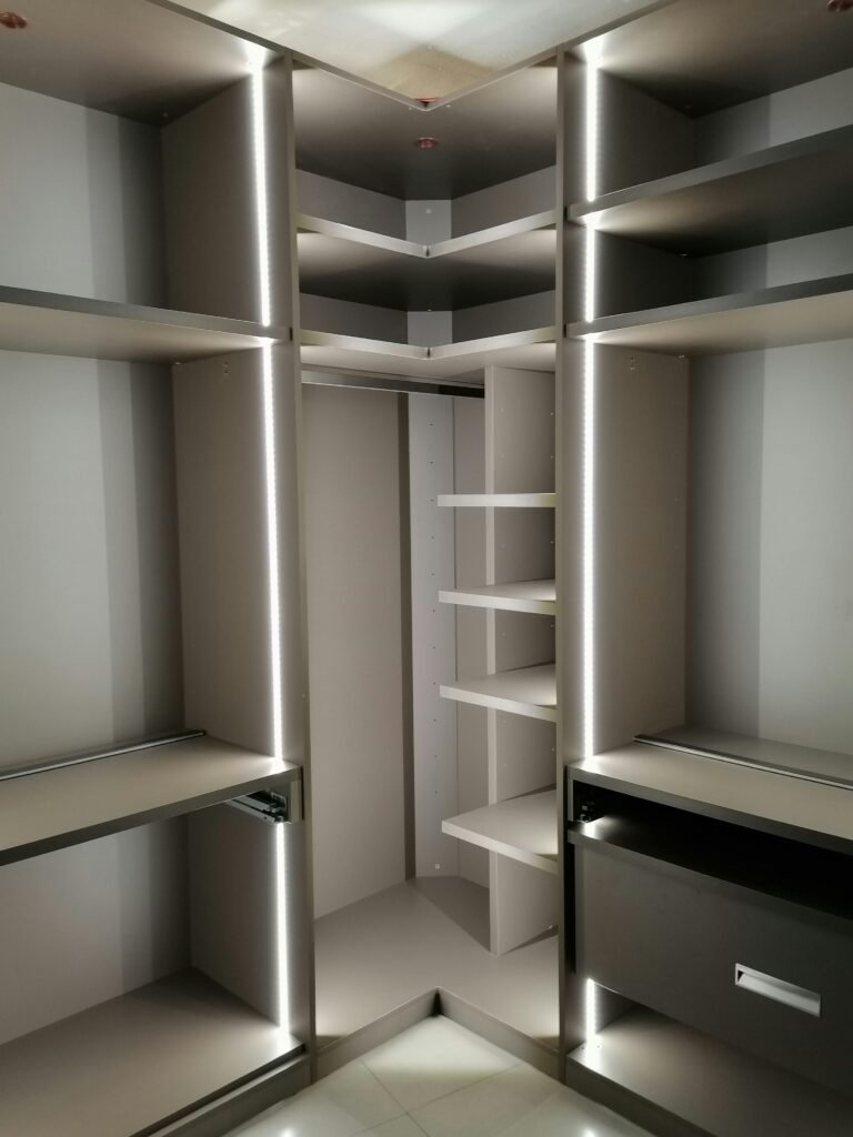 Elegant empty walk-in closet with built-in LED lighting and open shelving.